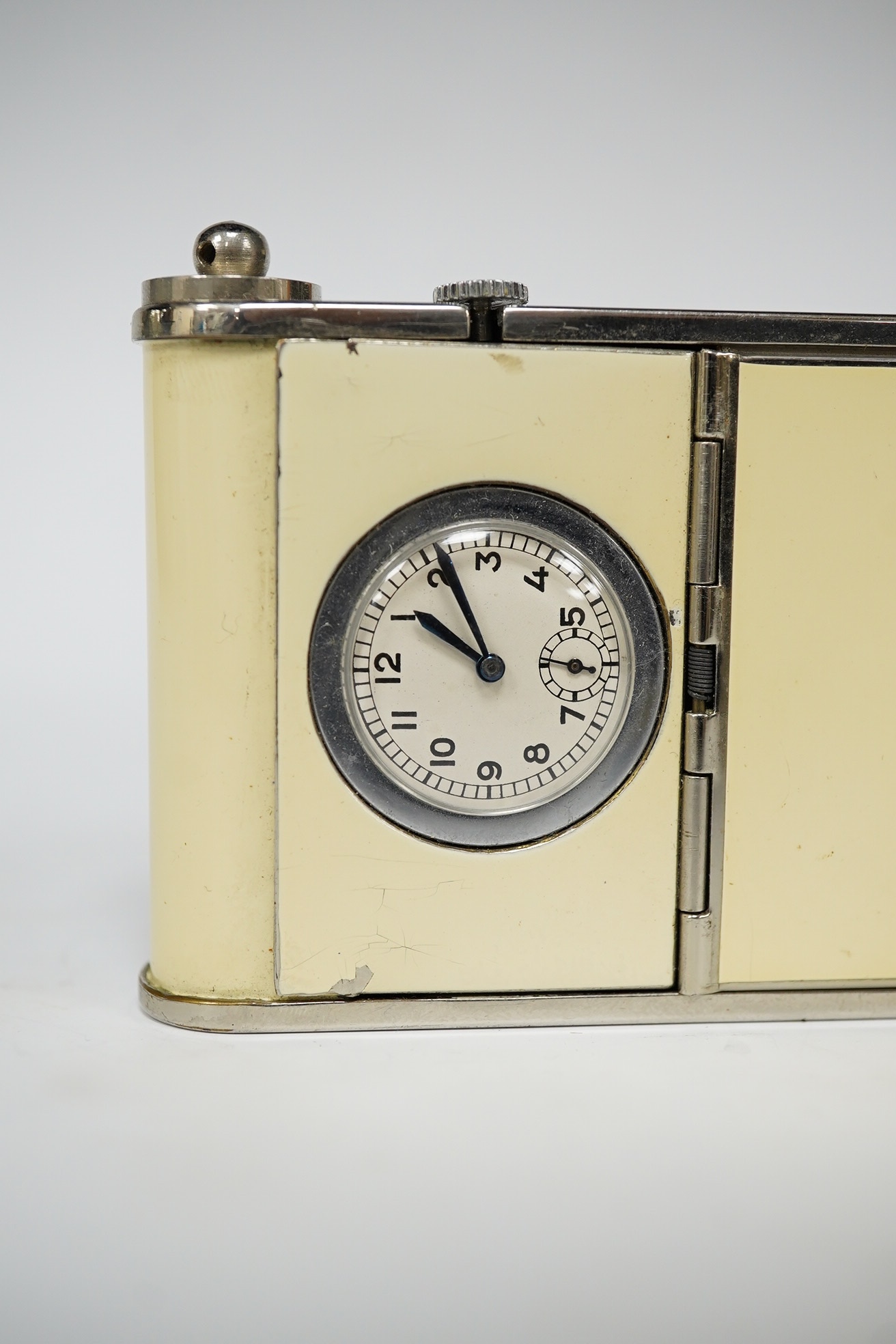 An Art Deco enamelled and chromed combined compact, a cigarette case and a timepiece, 9.5cm. Condition - minor flaking, movement going